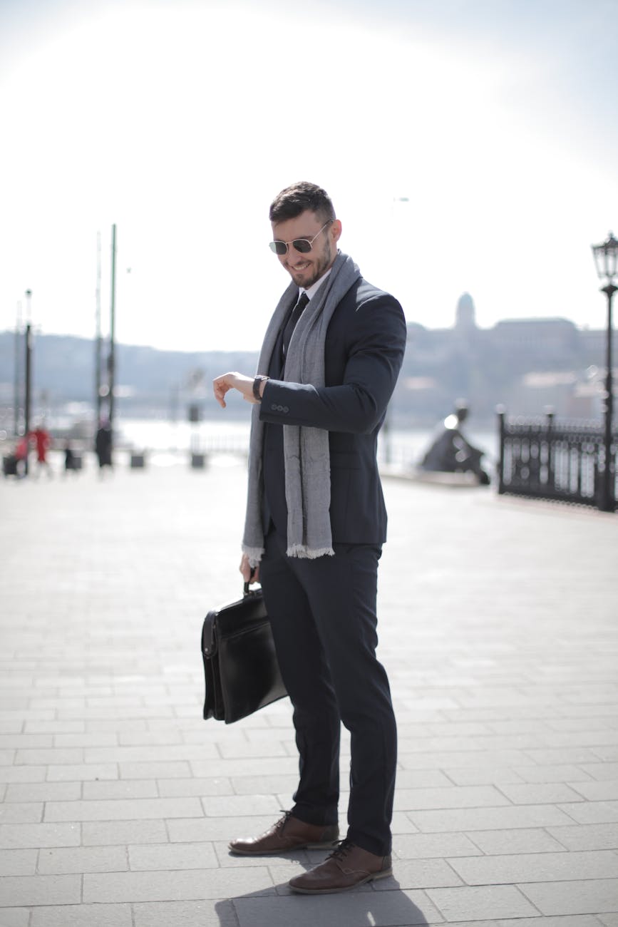 man in black suit holding leather briefcase